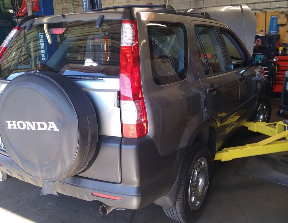 Honda CRV on mechanic lift to inspect undercar components. Ventura car repair experts.